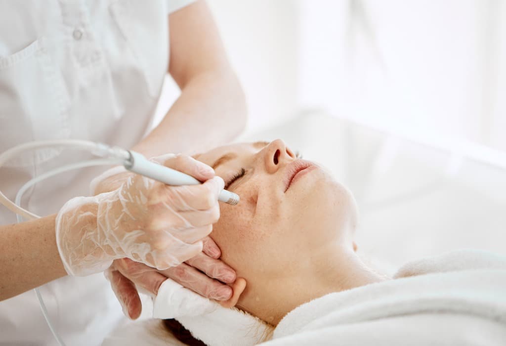 Face Beauty Treatment. Close up of female client getting facial gas-liquid oxygen water epidermal peeling using hardware apparatus